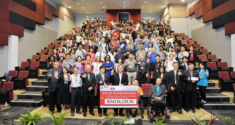 Prof Ir Dr Lee (sixth from left) holding up a mock cheque and accompanied by senior TAR UC officials, students and representatives from the various charitable organisations at the cheque presentation ceremony.