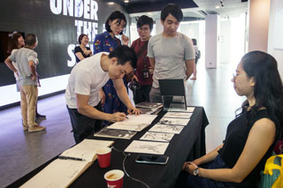 Sin Way Chyuan signing an artbook for fellow attendees at the launch