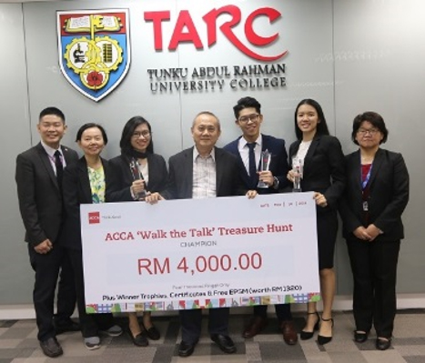 A mock cheque of the grand prize being held with pride by Datuk Dr Tan Chik Heok (centre), President of TAR UC  while the students namely Lee Yweng Yan (third from left), Wong Fook Chin (third from right) and Isabelle Pong Wen-Xin (second from right) posing with their trophies  accompanied by Ms Wong Hwa Kiong (rightmost), Dean of the Faculty of Accountancy, Finance and Business (‘FAFB’), Ms Yeo Liu Choo (second from left),  Associate Dean of Department of Accountancy, FAFB and Mr Chuah Chin Leong (leftmost), Associate Dean, Department of Professional Accountancy, FAFB. Cha Chin Seng was not present when this photo was taken.