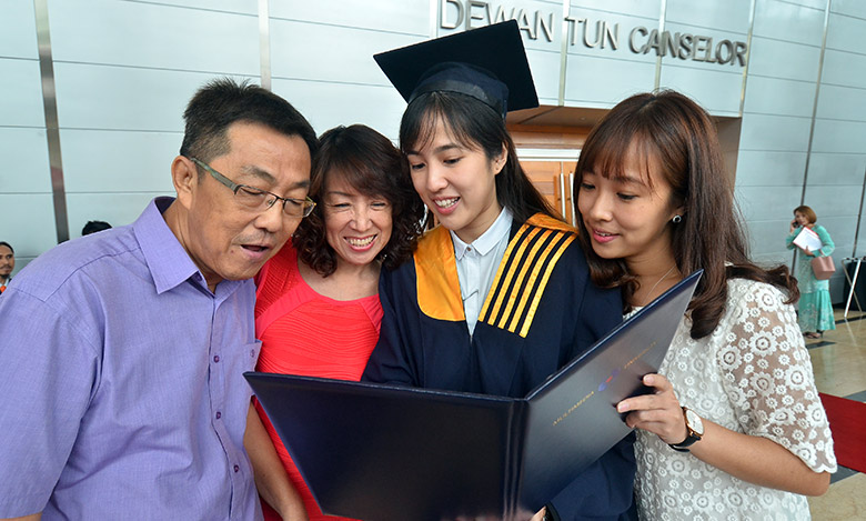 Elynn Kuan (second from right) showing her scroll to family members after MMU Convocation Ceremony, Cyberjaya.