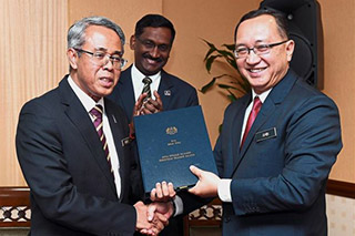 Dr Amin (right) shaking hands with Dr Khair during the clock out ceremony for the outgoing D-G at the ministry, which was also attended by Deputy Education Minister Datuk P Kamalanathan (centre). — Bernama